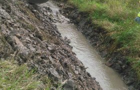 Using an excavator to control the flow of water