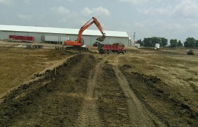 Excavator placing excess aggregate into a dump truck for haul away