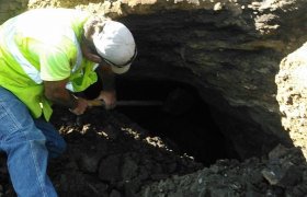 Crew member manually digging with a shovel