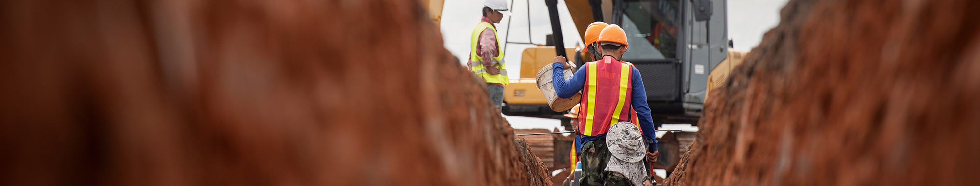 Low level photograph of excavating crew members working in a trench