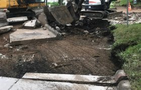 Selly Excavating using a large excavator to remove an old paved roadway