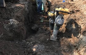 Crew member of Selly Excavating working in a trench to install a city drainage system