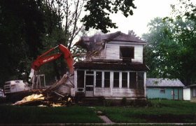 Selly Excavating using a large excavator to demolish a two story house